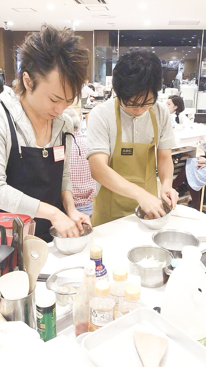 料理学校に通って料理を習う男性2人の画像